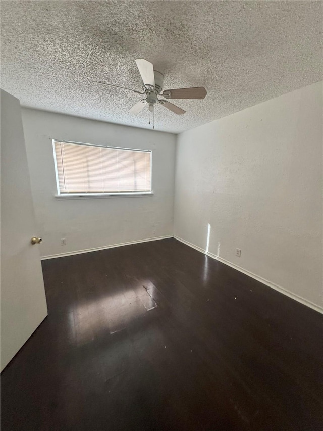 spare room featuring wood finished floors, a textured ceiling, ceiling fan, and plenty of natural light