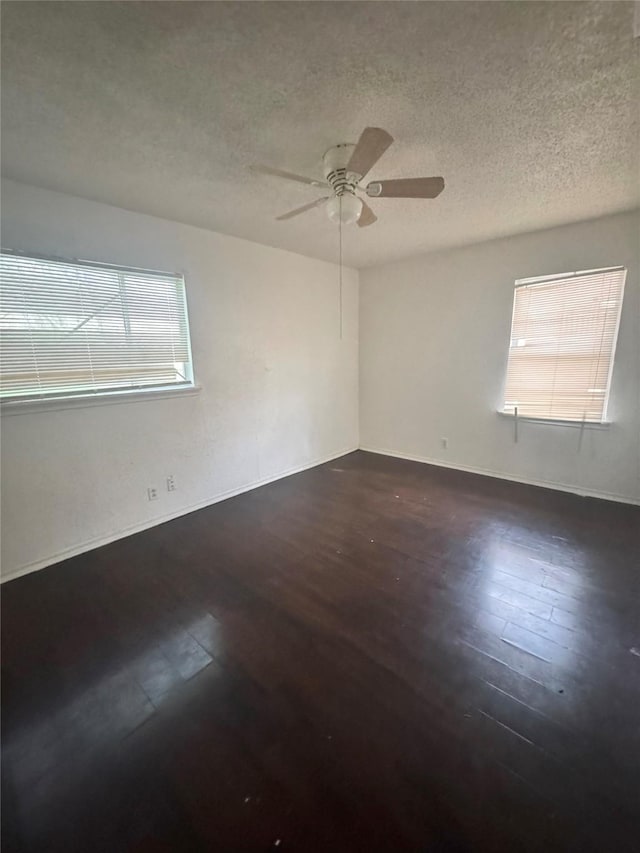 empty room with baseboards, wood finished floors, a textured ceiling, and ceiling fan