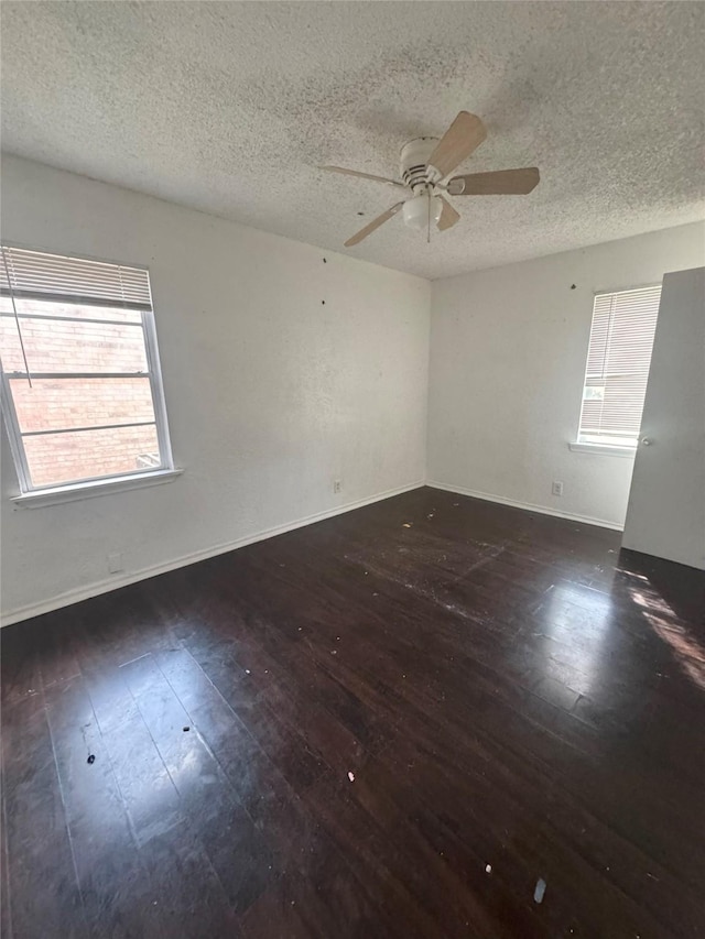 empty room featuring hardwood / wood-style floors, a textured ceiling, a ceiling fan, and baseboards