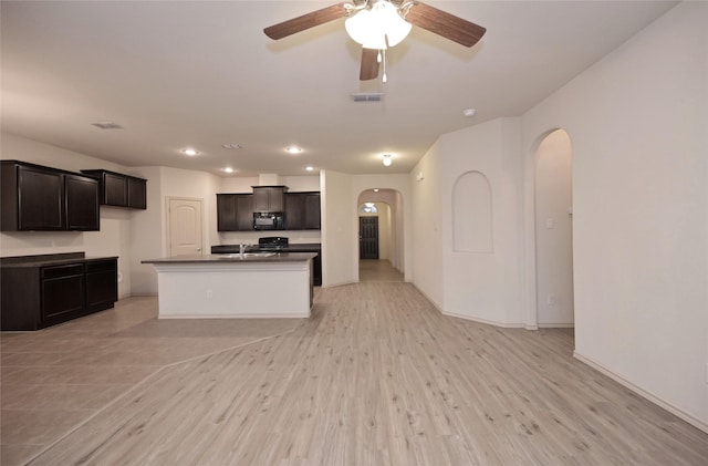 kitchen featuring recessed lighting, dark countertops, arched walkways, black microwave, and ceiling fan