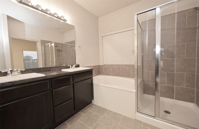bathroom with a sink, double vanity, a stall shower, tile patterned flooring, and a garden tub
