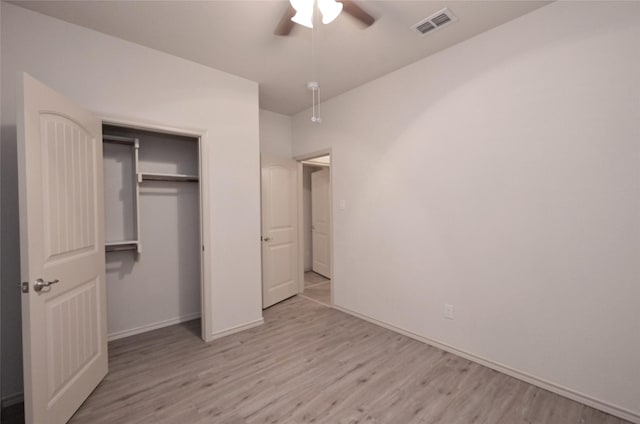 unfurnished bedroom with wood finished floors, visible vents, a ceiling fan, a closet, and baseboards