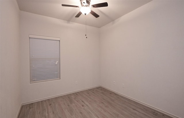 spare room featuring wood finished floors, baseboards, and ceiling fan