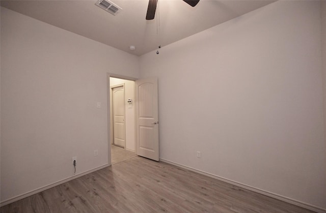 spare room featuring baseboards, a ceiling fan, wood finished floors, and visible vents