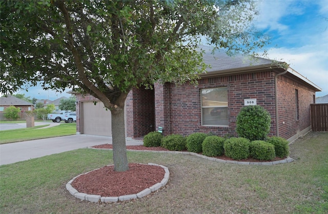 obstructed view of property featuring fence, roof with shingles, driveway, brick siding, and a front yard