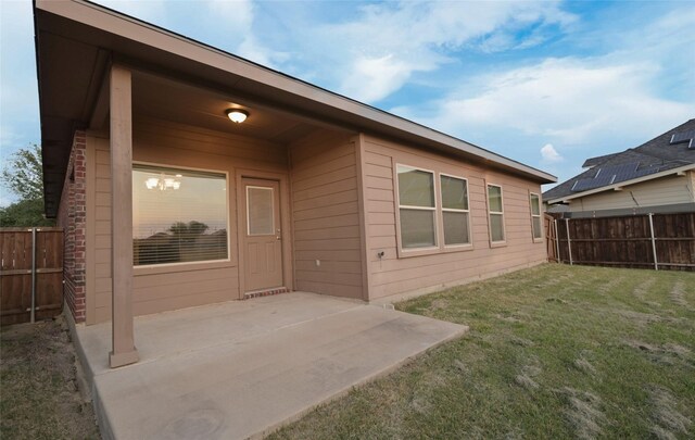 back of property with a lawn, a fenced backyard, and a patio