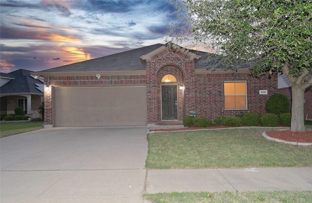ranch-style house featuring a garage, driveway, a shingled roof, a front yard, and brick siding