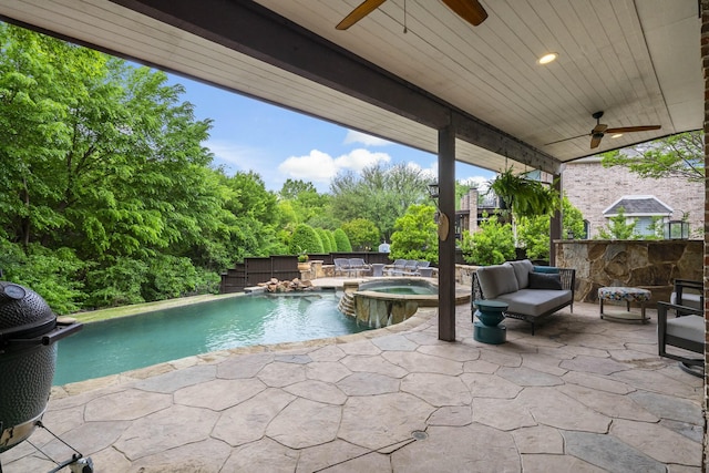 view of pool with grilling area, a patio area, a pool with connected hot tub, and ceiling fan