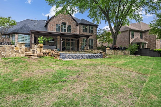 rear view of property with a lawn, brick siding, fence, and a shingled roof
