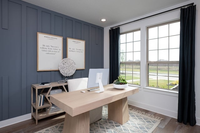 office space with wood finished floors, recessed lighting, a decorative wall, and baseboards