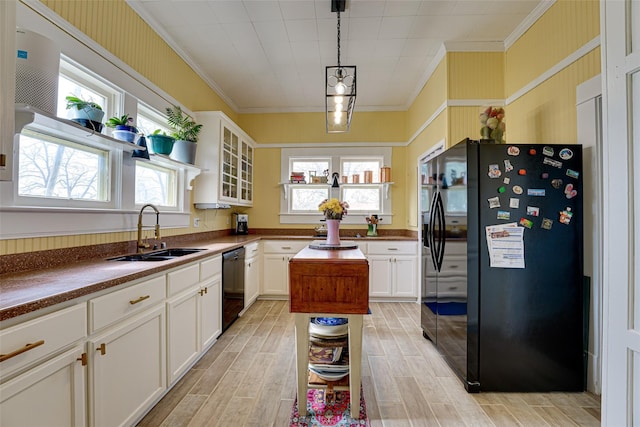 kitchen featuring white cabinetry, ornamental molding, a sink, and black appliances