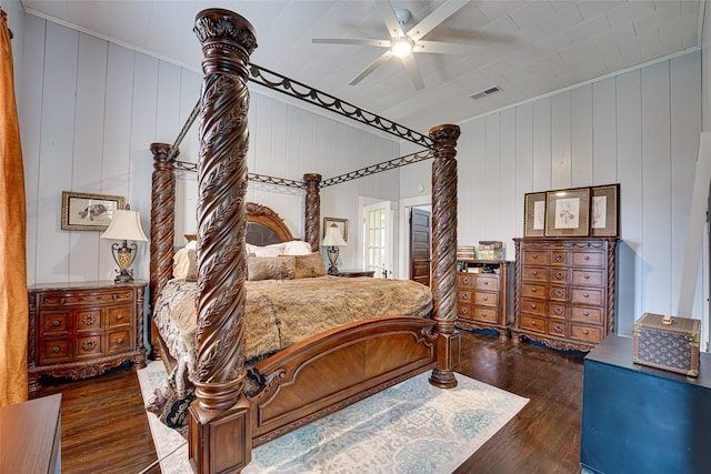 bedroom featuring ceiling fan, wood walls, hardwood / wood-style floors, and visible vents