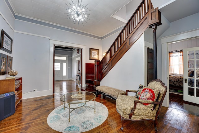 entrance foyer with baseboards, an inviting chandelier, stairs, hardwood / wood-style flooring, and ornamental molding