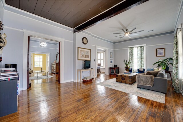 living area with beamed ceiling, hardwood / wood-style floors, visible vents, and ceiling fan