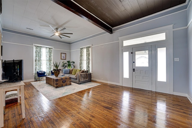 interior space featuring hardwood / wood-style floors, ceiling fan, baseboards, beam ceiling, and visible vents