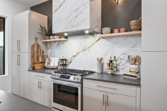 kitchen featuring open shelves, dark countertops, a barn door, wall chimney exhaust hood, and a sink
