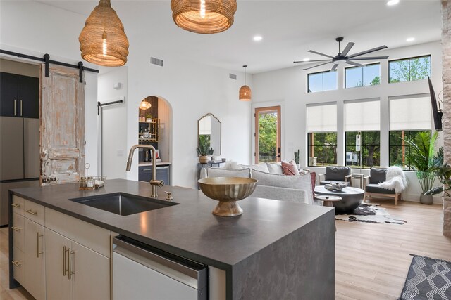 kitchen with dark countertops, a sink, gas range, range hood, and tasteful backsplash