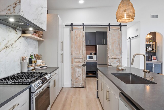 kitchen with visible vents, dark countertops, open floor plan, ceiling fan, and a sink