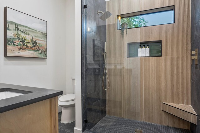 full bath with toilet, a marble finish shower, and vanity