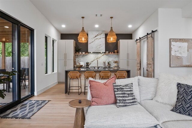 living area featuring beverage cooler, light wood-style flooring, visible vents, and a bar