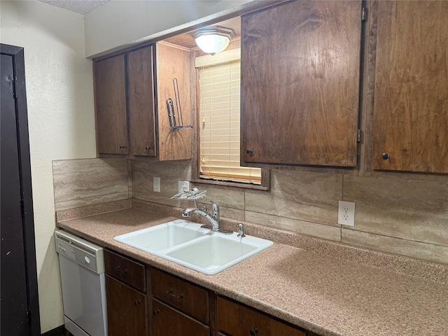 kitchen with white dishwasher, dark brown cabinets, decorative backsplash, and a sink