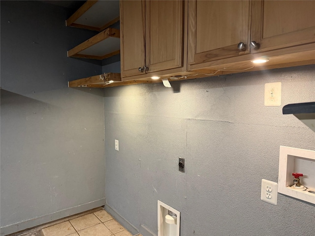 clothes washing area with light tile patterned floors, hookup for an electric dryer, baseboards, cabinet space, and washer hookup