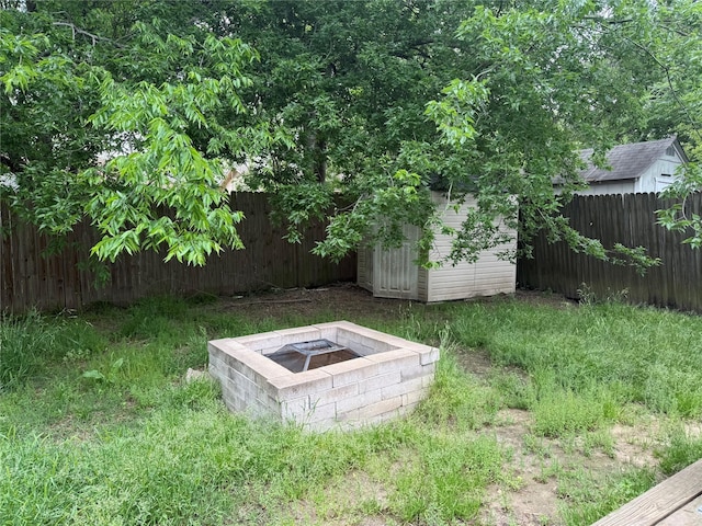 entry to storm shelter featuring a fenced backyard, an outbuilding, and a storage shed