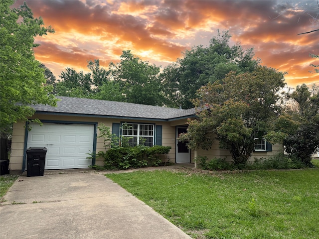 view of front facade with a lawn, driveway, and a garage