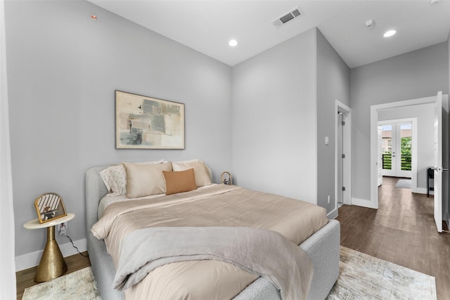 bedroom with baseboards, french doors, wood finished floors, and visible vents