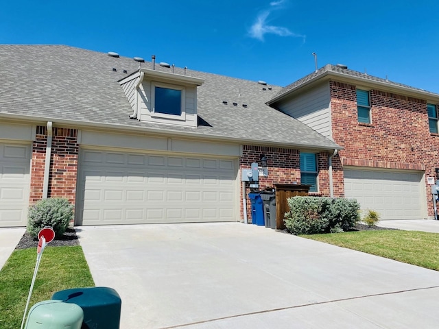 view of front of property with concrete driveway, brick siding, and roof with shingles
