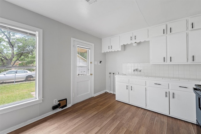 3717 Parkwood St, Waco, TX 76710 - kitchen featuring light wood finished floors, plenty of natural light, light countertops, and tasteful backsplash