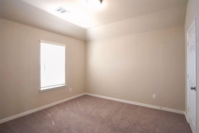 carpeted empty room featuring baseboards and visible vents