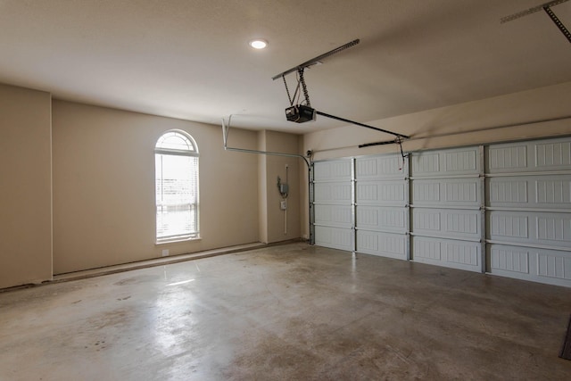 garage with a garage door opener and recessed lighting