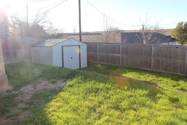 view of yard featuring an outdoor structure, a shed, and a fenced backyard