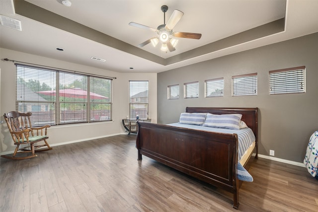 bedroom featuring wood finished floors, visible vents, and baseboards