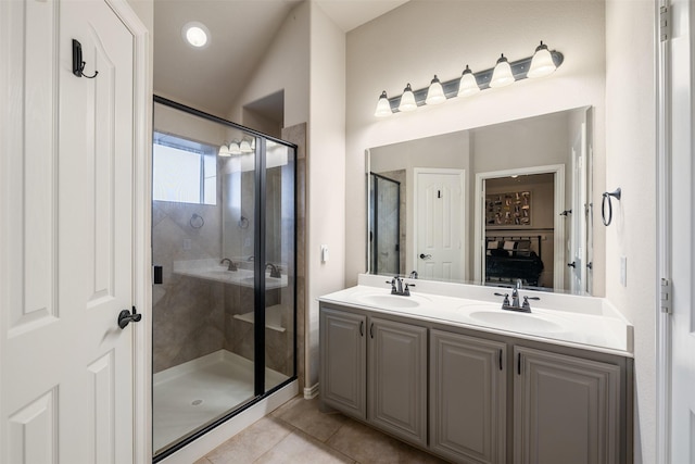 bathroom with tile patterned flooring, a sink, double vanity, and a stall shower