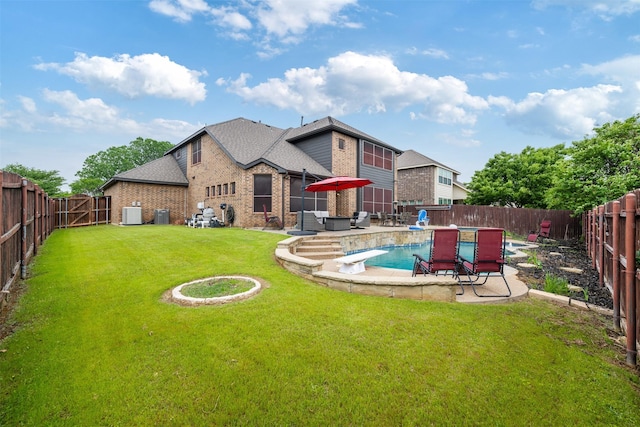 rear view of property with a fenced backyard, brick siding, a patio area, and a yard