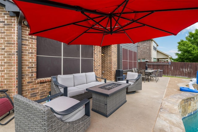 view of patio featuring an outdoor living space with a fire pit, outdoor dining area, and fence