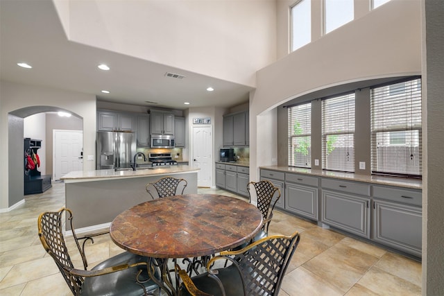dining room featuring light tile patterned floors, arched walkways, visible vents, and recessed lighting