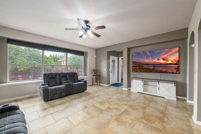 living room with a ceiling fan and baseboards