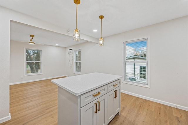 kitchen featuring baseboards, a healthy amount of sunlight, pendant lighting, and light wood-style flooring