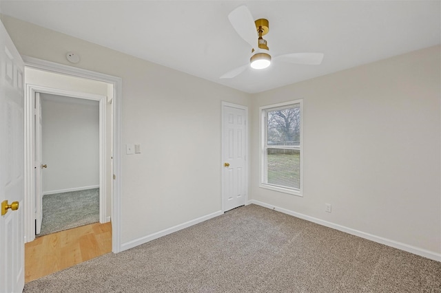 unfurnished room with a ceiling fan, baseboards, and light carpet