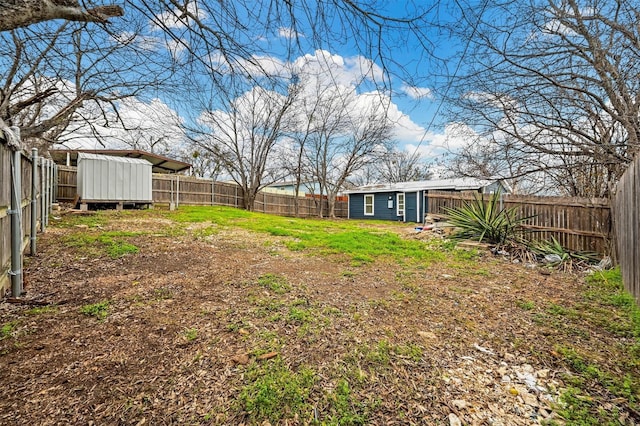 view of yard featuring a fenced backyard, an outbuilding, and a shed