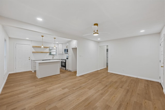 unfurnished living room featuring light wood finished floors, baseboards, recessed lighting, and ceiling fan