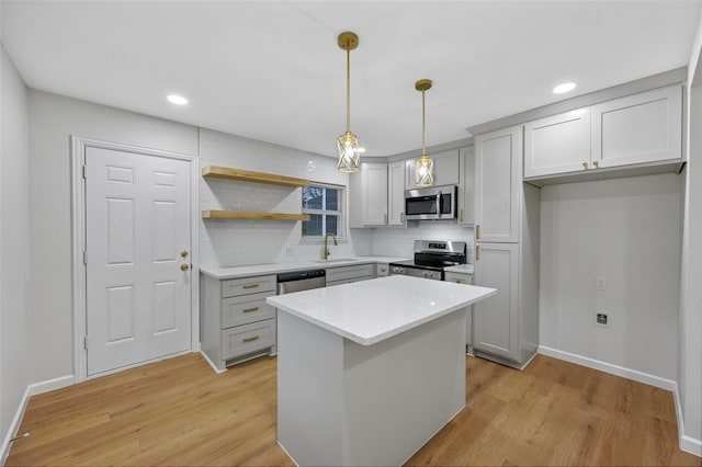 kitchen with a sink, decorative backsplash, light wood-type flooring, baseboards, and appliances with stainless steel finishes