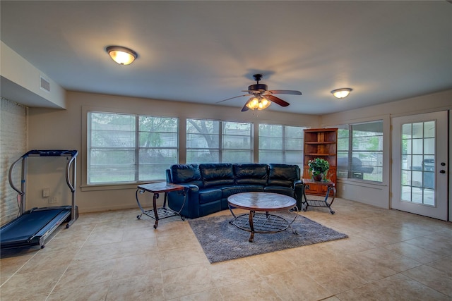 living room with light tile patterned floors, a ceiling fan, visible vents, and plenty of natural light