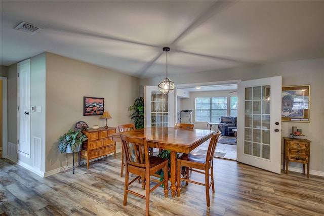 dining room featuring visible vents, baseboards, french doors, and wood finished floors