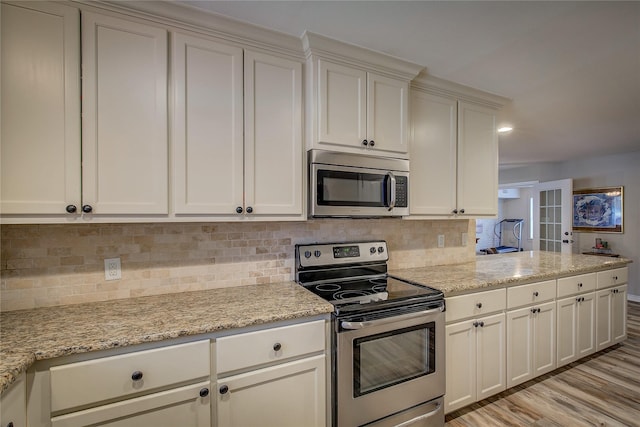 kitchen with light wood finished floors, stainless steel appliances, light stone countertops, and tasteful backsplash