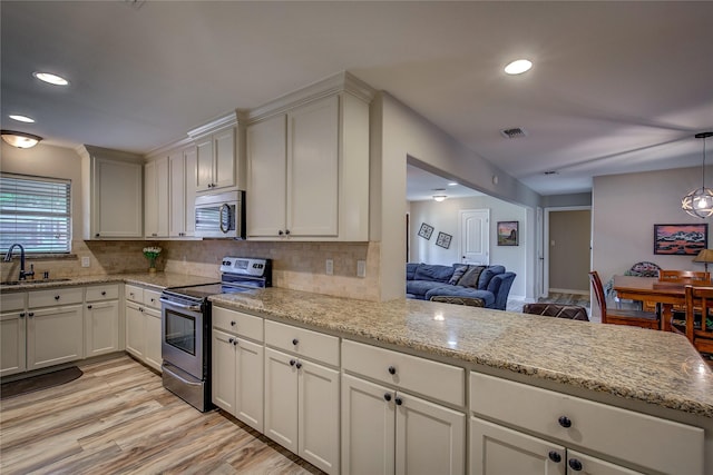 kitchen with tasteful backsplash, visible vents, stainless steel appliances, and a sink