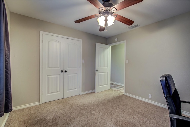 unfurnished office with ceiling fan, baseboards, visible vents, and carpet